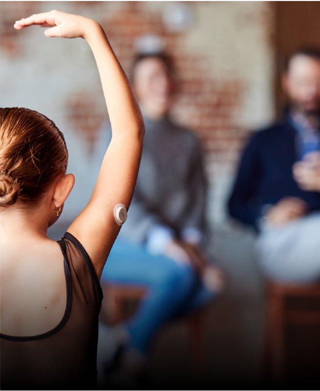 A ballerina wearing a Dexcom G7 sensor